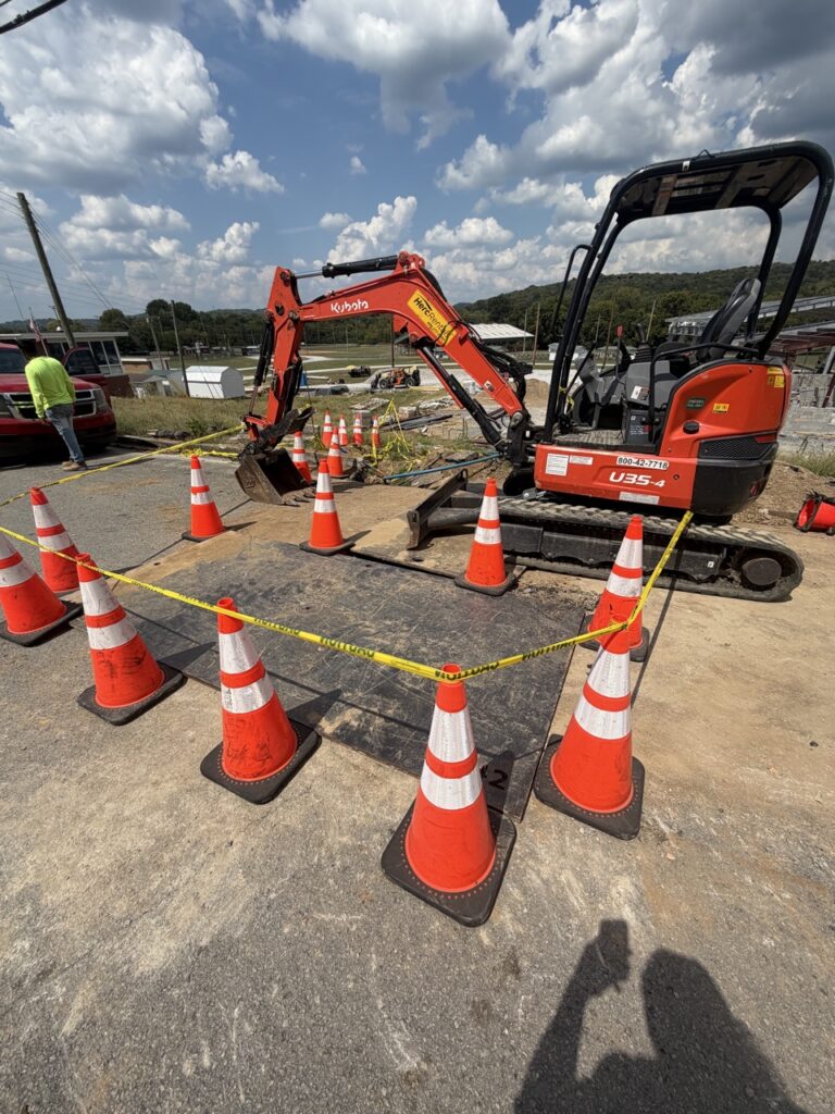 Mini excavator and cones during utility work at Cannon County EOC