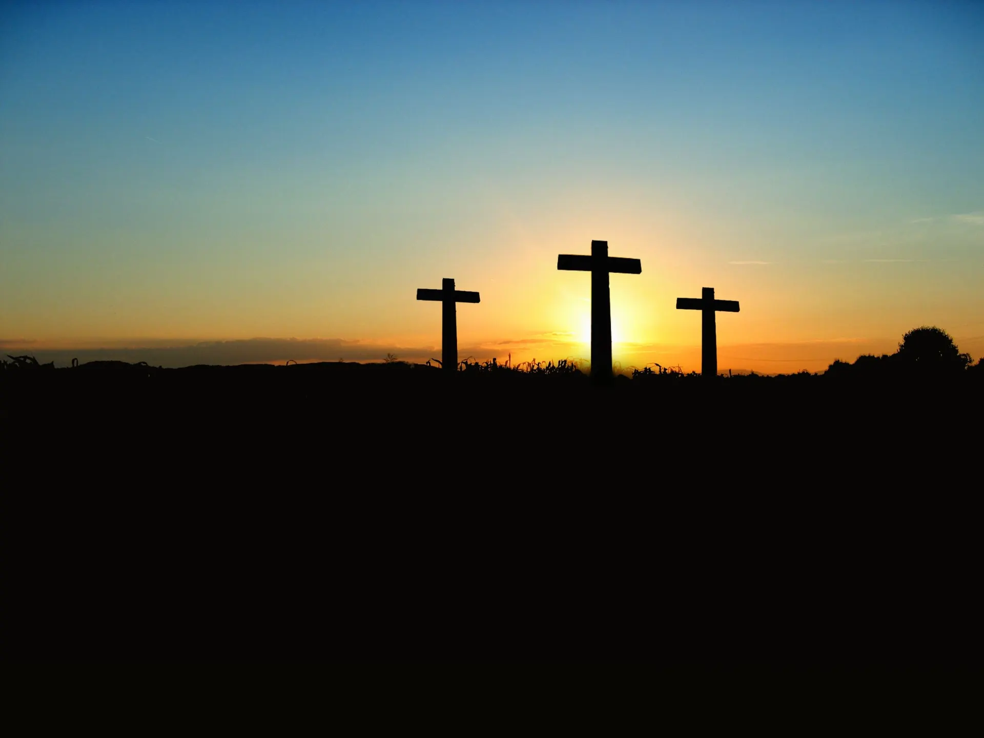 Three crosses silhouetted against a sunset sky