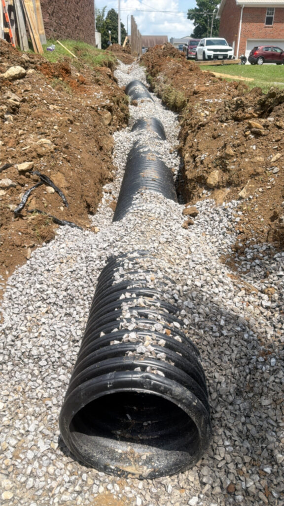Storm drain trench with pipe and stone bedding in Shelbyville